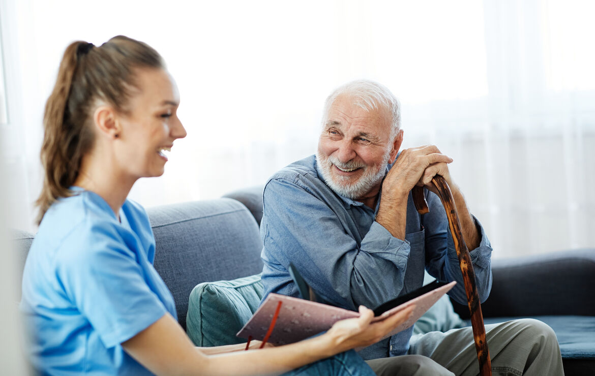 Senior mit Krankenpflegerin auf dem Sofa